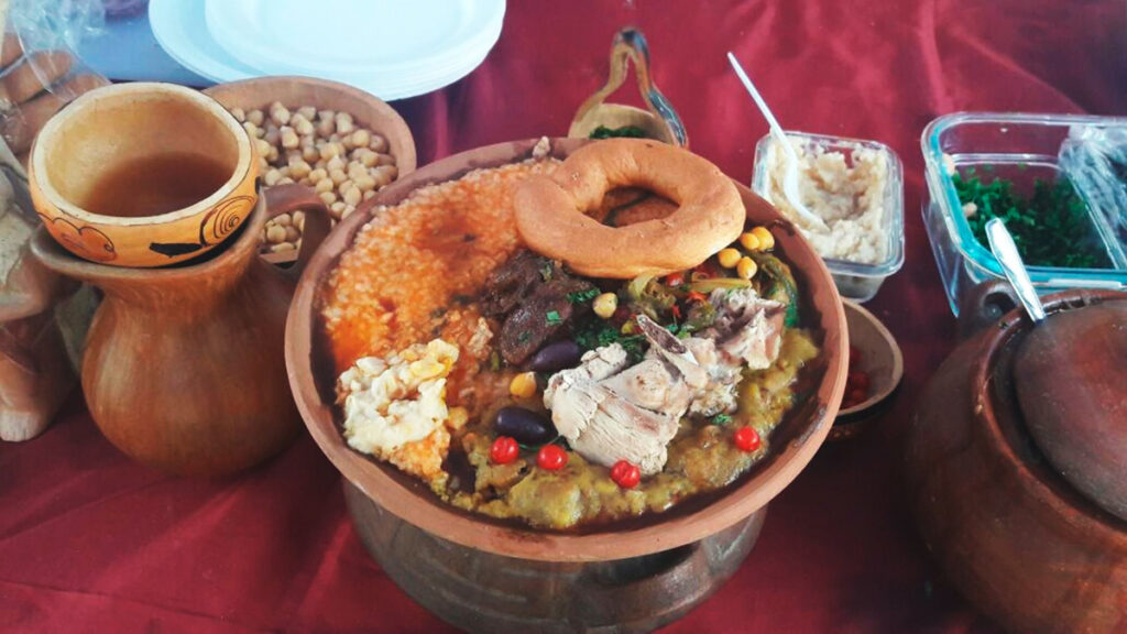 Sopa teóloga servida en plato tradicional con carnes, pan remojado y guarniciones típicas del norte peruano
