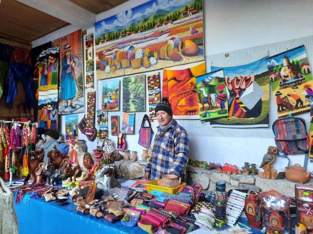 Artesano de San Pedro de Cajas mostrando sus productos textiles y artísticos en un mercado local