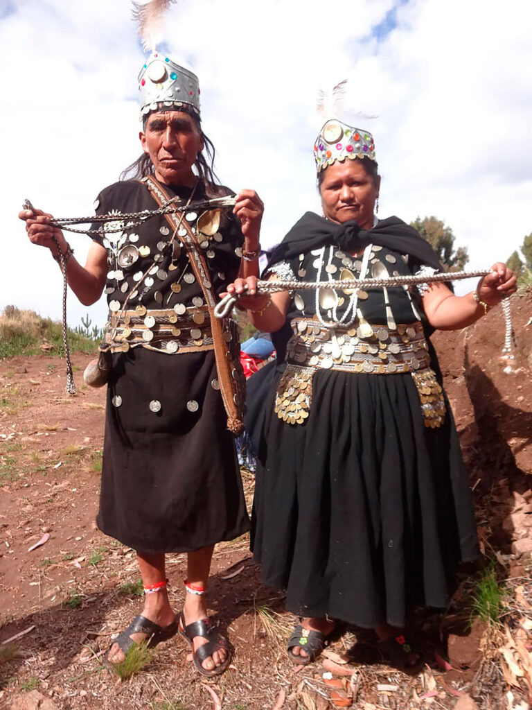 Vestimenta tradiciona de la danza Los Lupakas en Huaquina Sapijicani, con trajes adornados con monedas y coronas de plumas