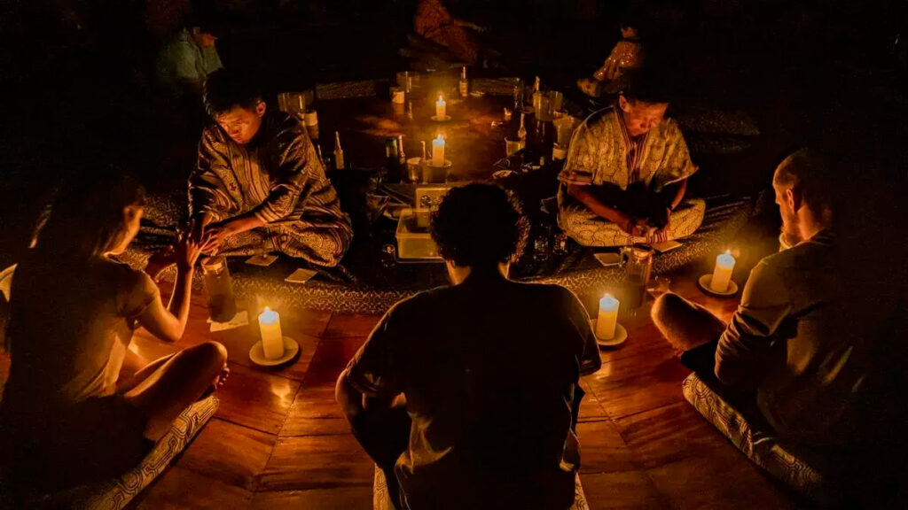 Ceremonia nocturna de ayahuasca guiada por un maestro tradicional en un espacio ritual iluminado por velas