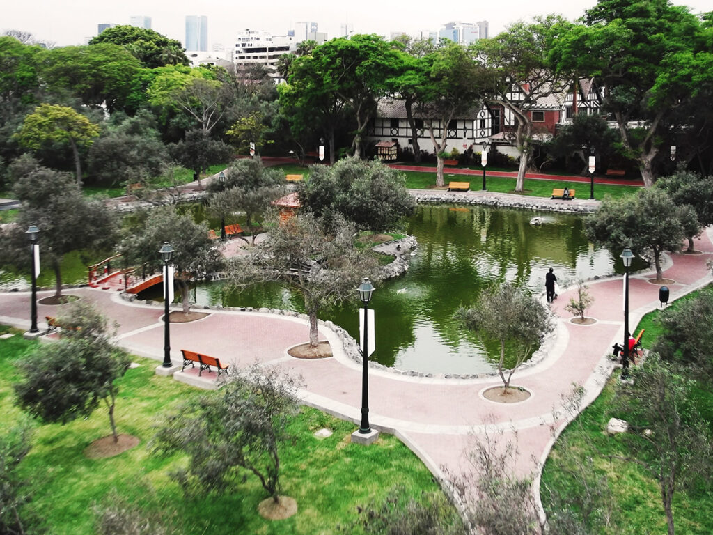Vista aérea del Bosque El Olivar con su estanque central, senderos empedrados y árboles centenarios en San Isidro