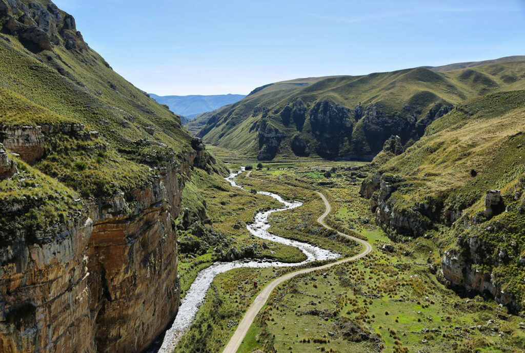 Cañón de Shucto en Jauja, con formaciones rocosas verticales y un río serpenteando entre praderas andinas