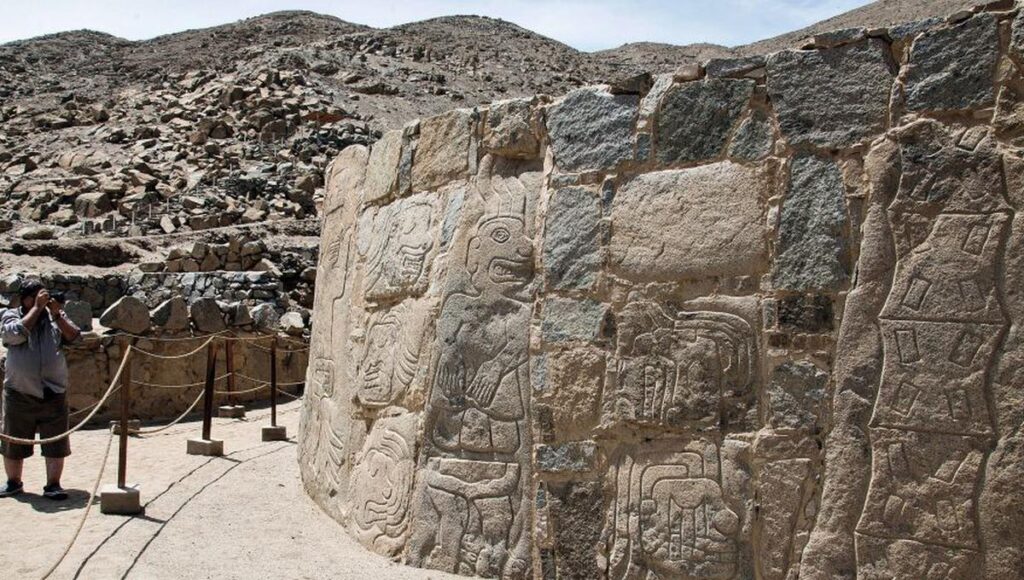 Muro de piedra con relieves de figuras humanas decapitadas en el complejo arqueológico de Sechín, región Áncash.
