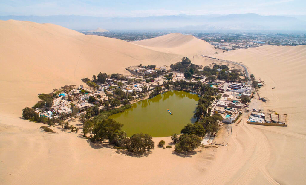vista aérea del oasis de Huacachina rodeado de dunas de arena