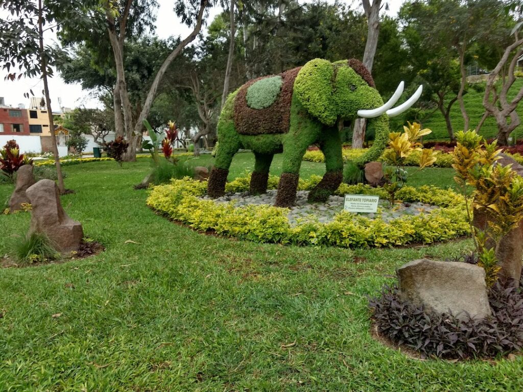 Escultura vegetal de elefante en el Parque Ecológico Loma Amarilla, rodeada de árboles y jardines