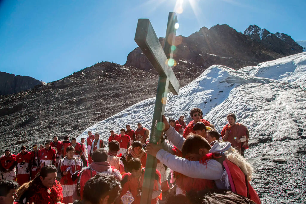 Peregrinos andinos participan en el Qoyllur Rit’i portando una cruz frente al nevado Ausangate