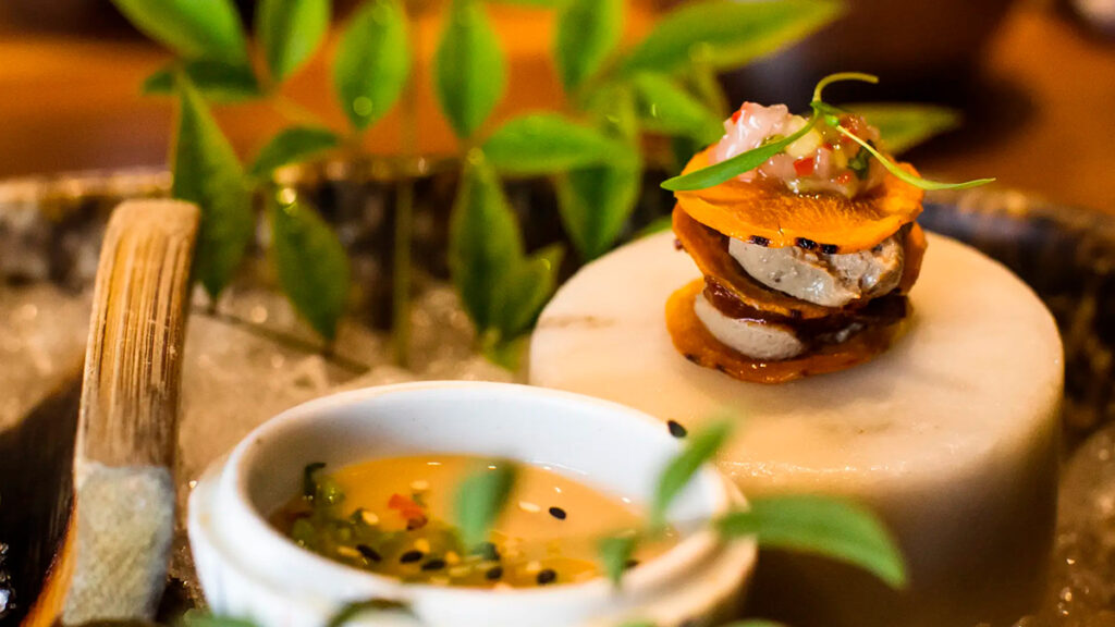 Plato de alta cocina nikkei servido en Maido, con montaje refinado y equilibrio entre ingredientes peruanos y japoneses