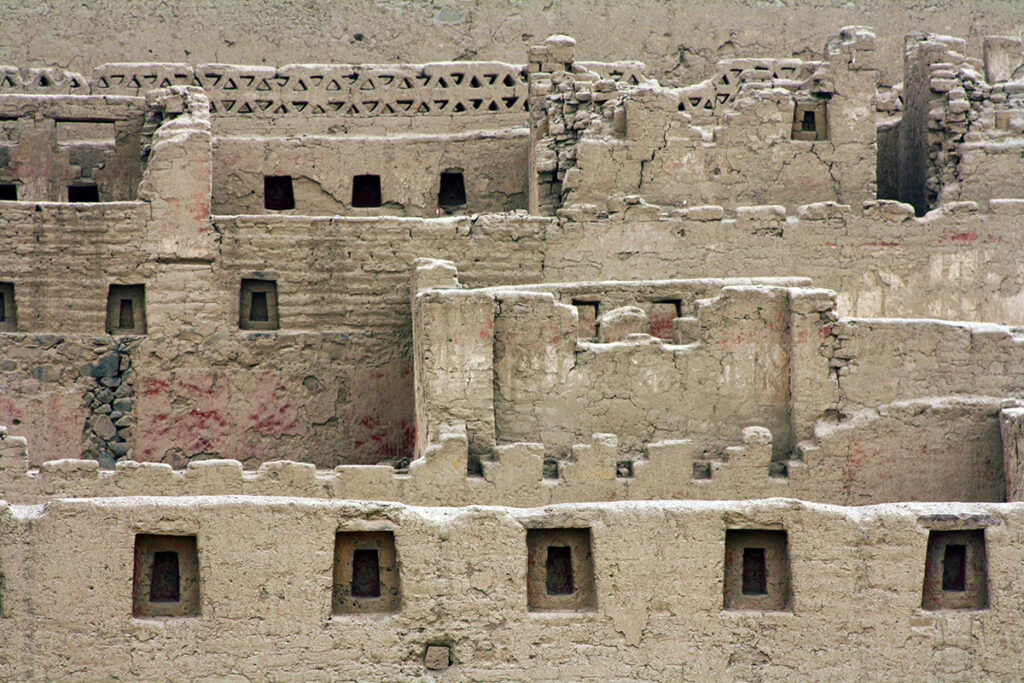 Muros de adobe de Tambo Colorado con nichos trapezoidales y restos visibles de pigmentos rojos, evidencia de la arquitectura incaica en la costa peruana