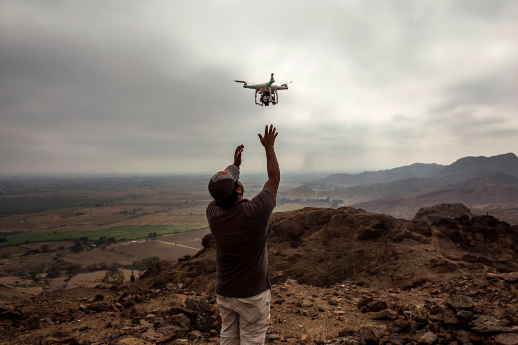 viajero operando un dron en un paisaje montañoso del Perú