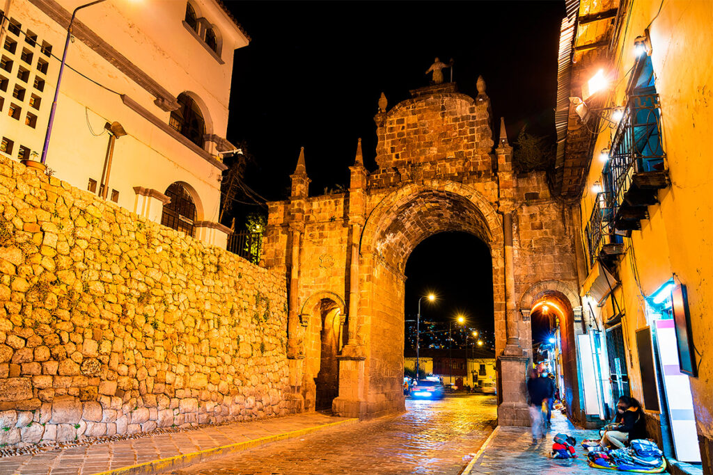 Arco de Santa Clara iluminado de noche en el centro histórico de Cusco