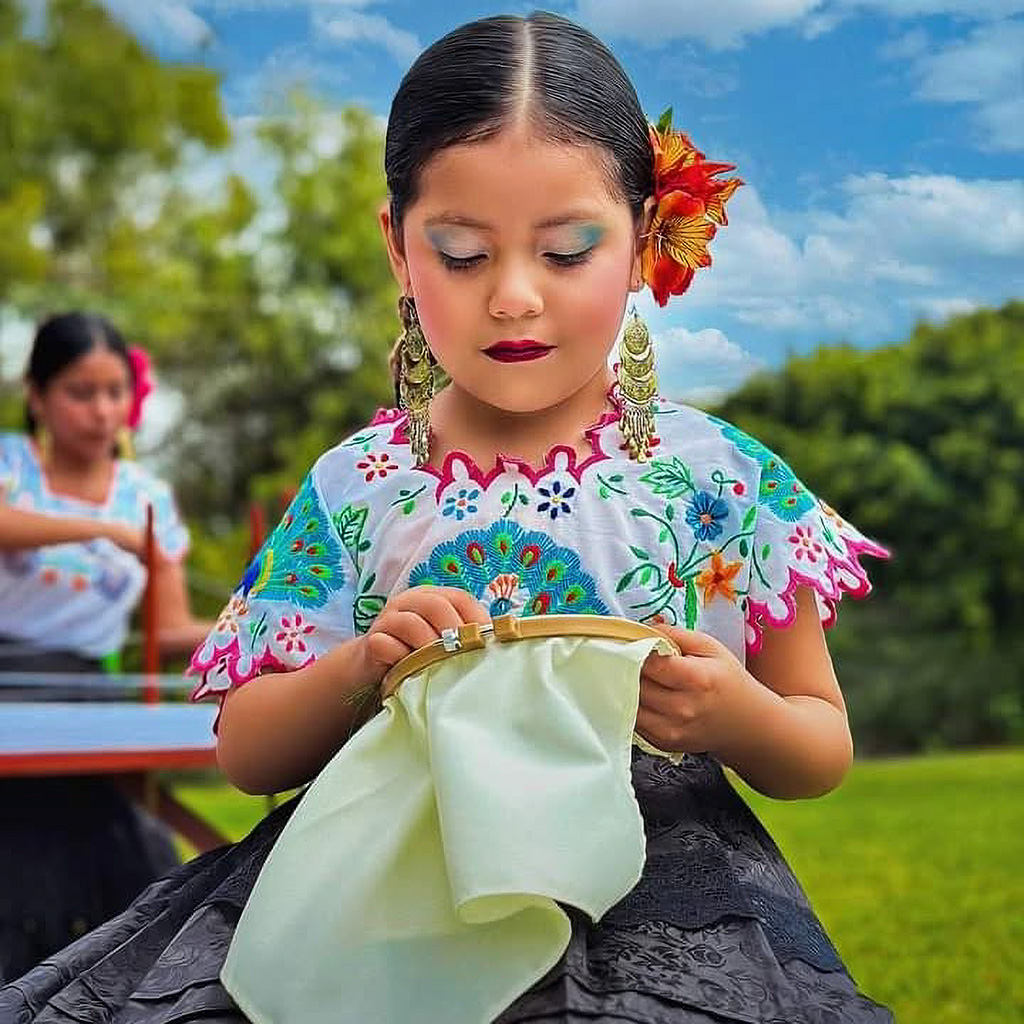 Niña monsefuana con traje típico bordando a mano, preservando la tradición textil de Monsefú