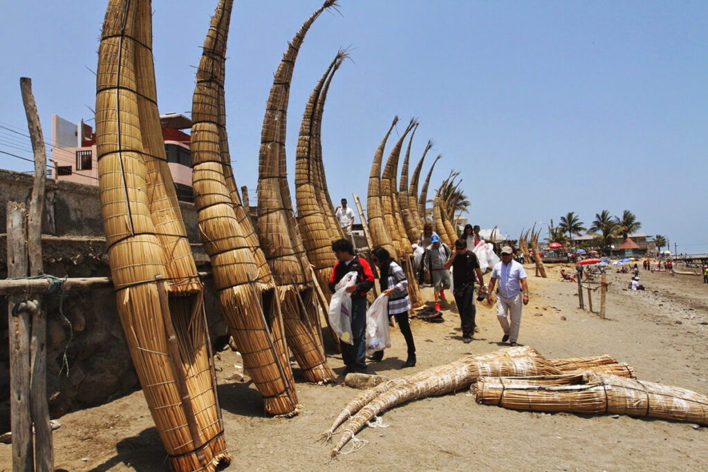 Caballitos de totora alineados en la playa de Huanchaco durante las celebraciones de San Pedro y San Pablo