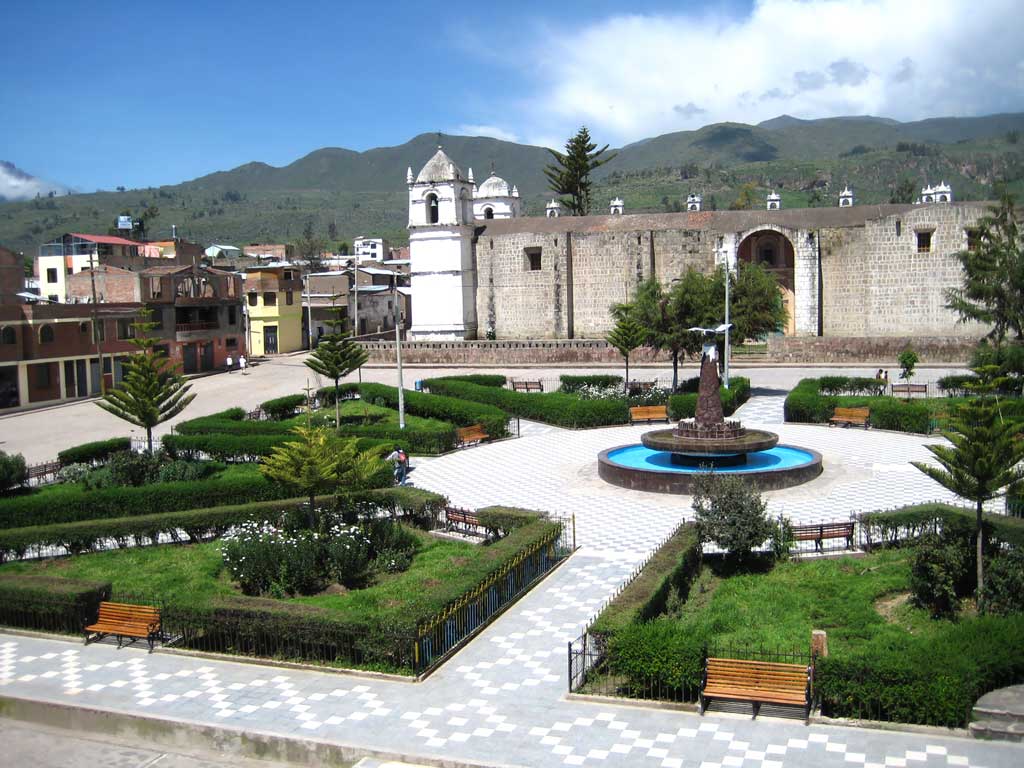 Plaza principal de Cabanaconde con su iglesia colonial y jardines, rodeada por montañas en el Valle del Colca