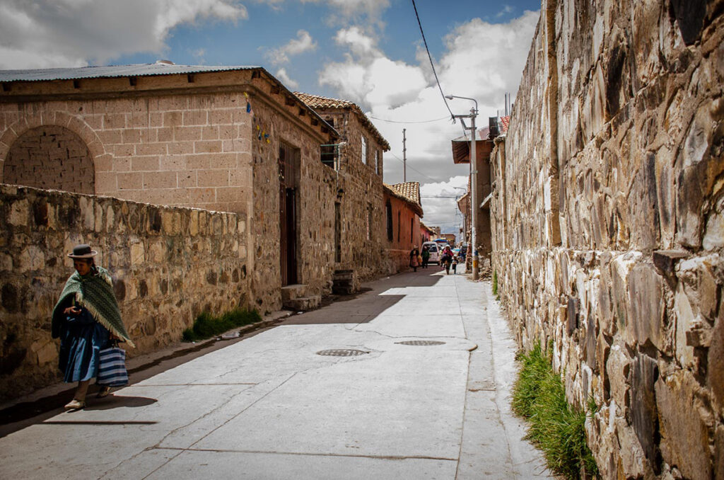 Calle empedrada de Lampa con casas coloniales y personas caminando en un día soleado