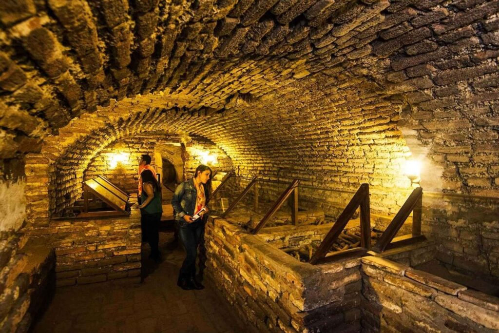 Visitantes recorriendo las catacumbas subterráneas del Convento de San Francisco en Lima