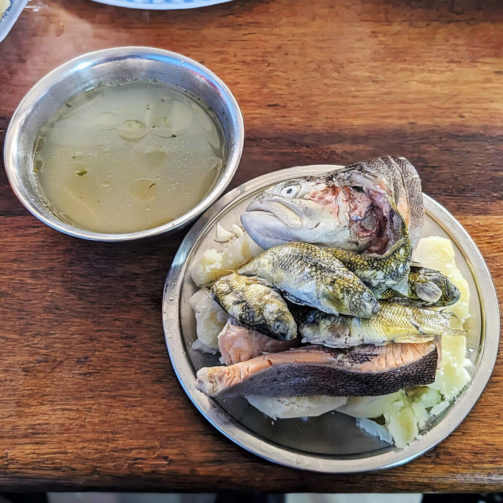 Chawlla Thimpu servido en dos platos: uno con caldo claro y otro con pescados nativos sobre papas sancochadas