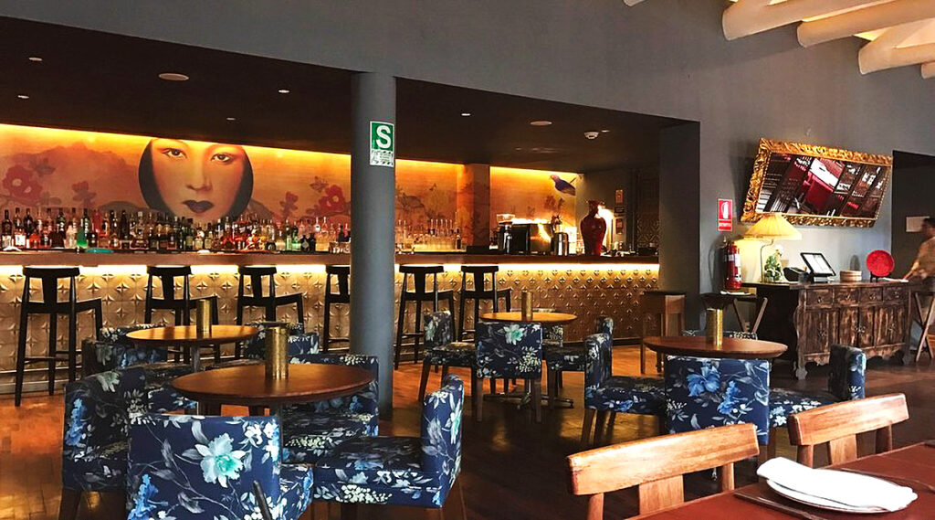 Interior del restaurante Kion Peruvian Chinese en Cusco, con decoración moderna, mural oriental y mobiliario elegante