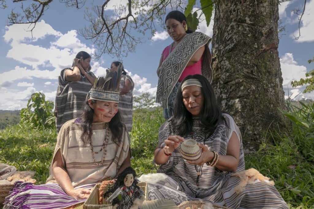 Mujeres machiguengas reunidas en la selva mientras realizan labores artesanales tradicionales