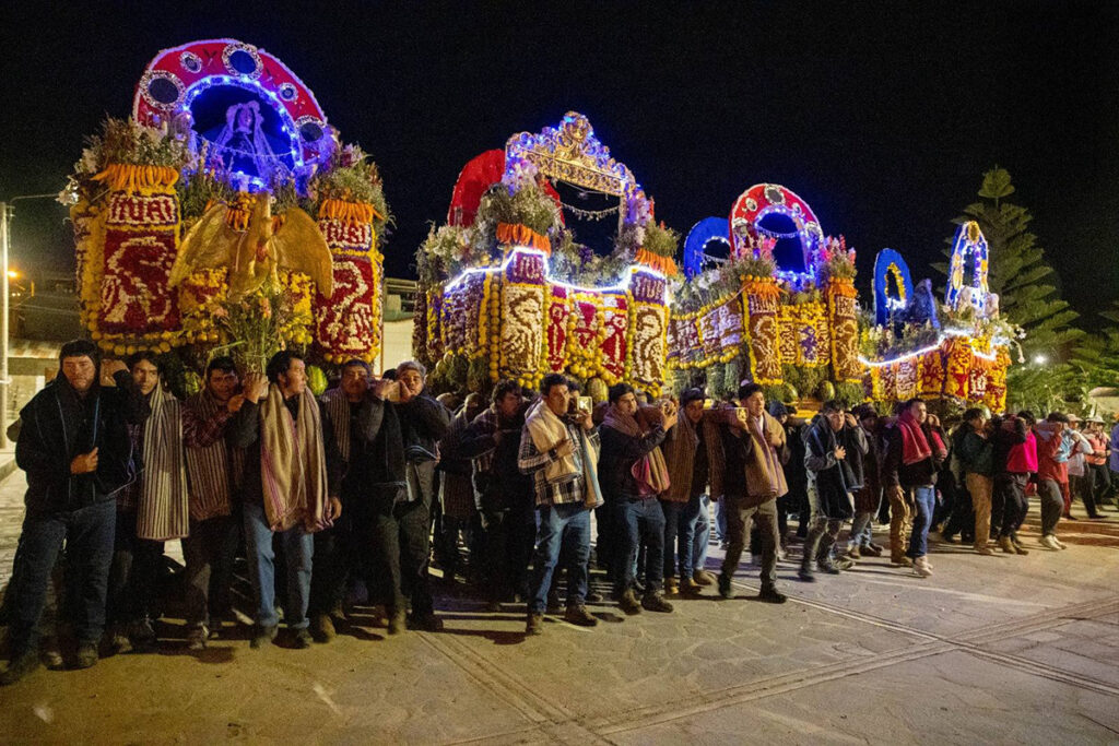 Procesión nocturna en Cabanaconde durante las fiestas patronales, con coloridos arreglos y participación de la comunidad
