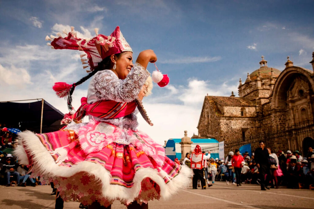 Mujer en traje típico puneño bailando frente a la iglesia de Santiago Apóstol en Lampa, Puno