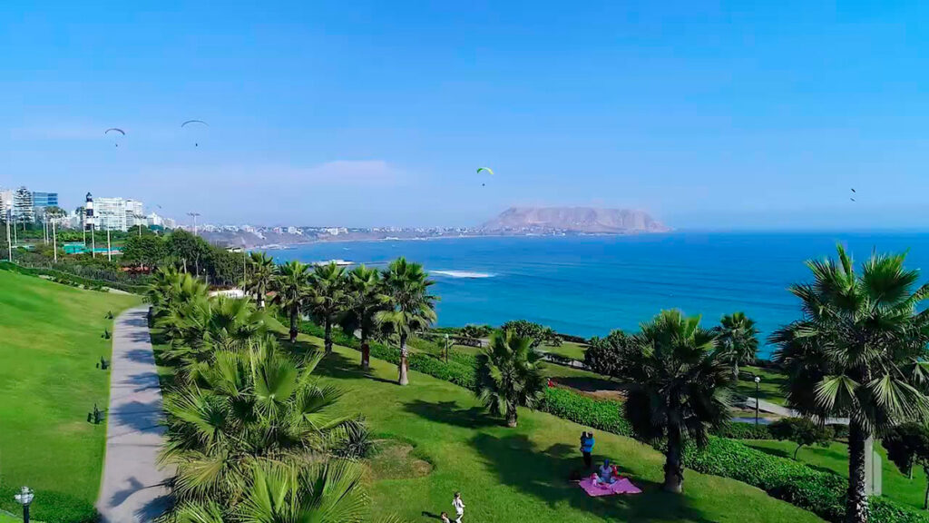 Vista del Malecón Cisneros con palmeras, senderos y parapentes sobre la Costa Verde