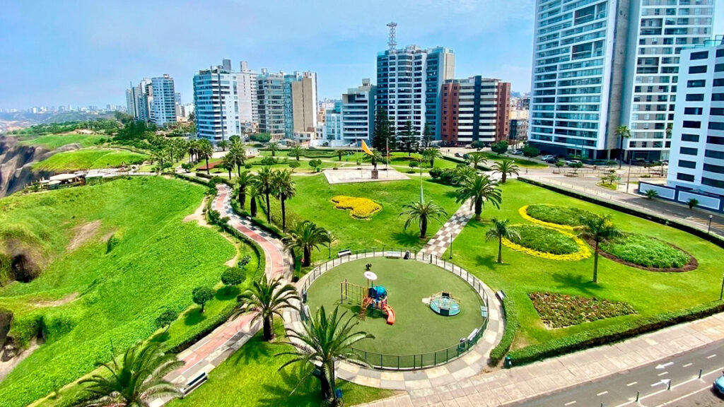 Vista del Malecón de la Marina con jardines, senderos curvos y edificios residenciales al fondo