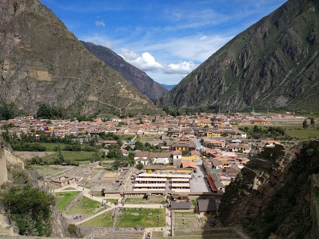 Vista aérea del pueblo de Ollantaytambo, rodeado de montañas y andenes, punto de partida hacia Pumamarka