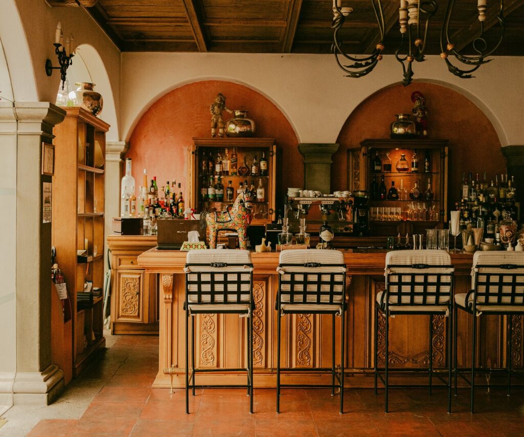 Barra interior del restaurante Senzo en el Belmond Palacio Nazarenas, con decoración colonial, madera tallada, lámparas colgantes y ambiente elegante