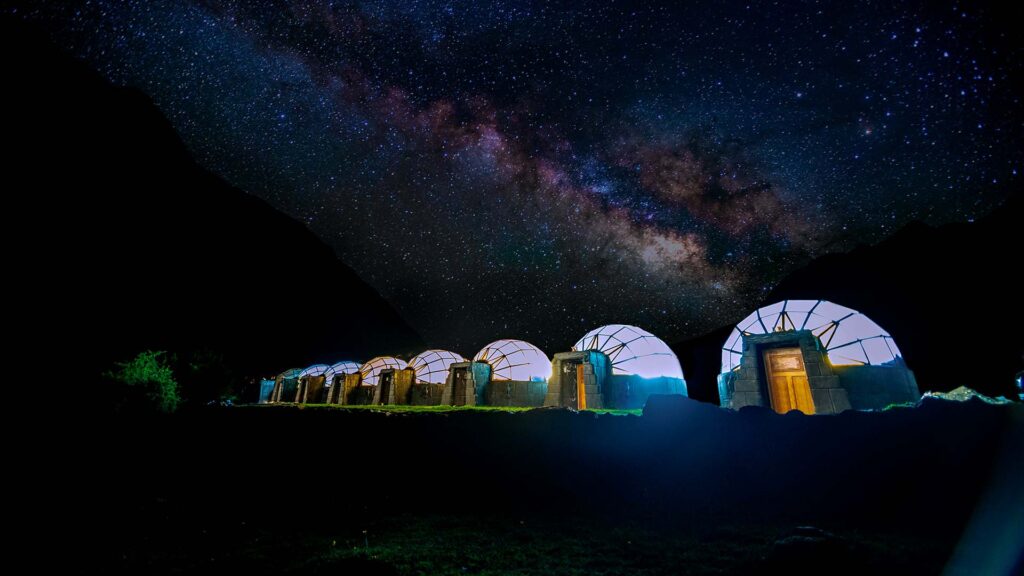 Domos del Sky Camp iluminados bajo el cielo estrellado cerca del nevado Salkantay en Perú