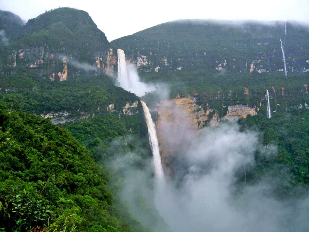 catarata Gocta en temporada de lluvias con gran caudal rodeada de vegetación y neblina