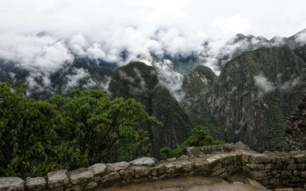 vista panorámica de Machu Picchu cubierta por nubes y neblina desde un mirador