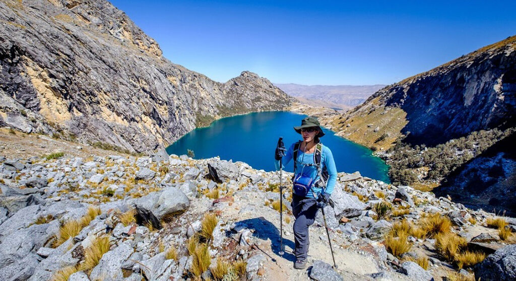 senderista con bastones frente a la Laguna de Churup en la Cordillera Blanca