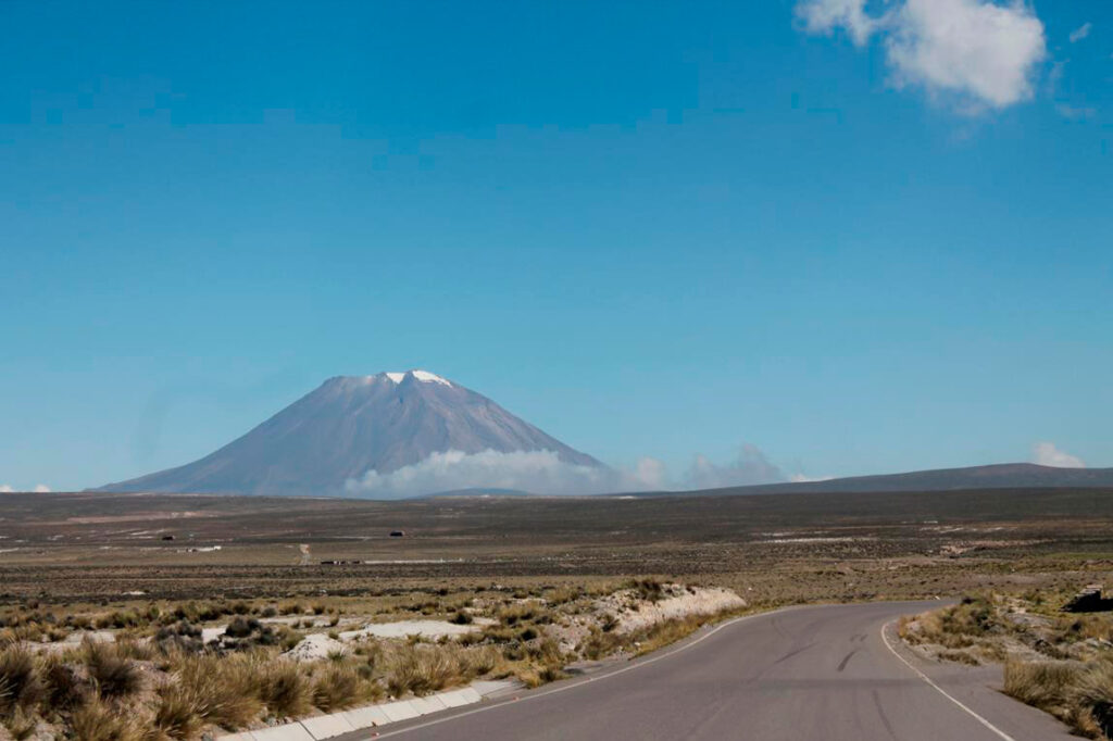 Carretera hacia Arequipa con vista a uno de sus volcanes en el horizonte