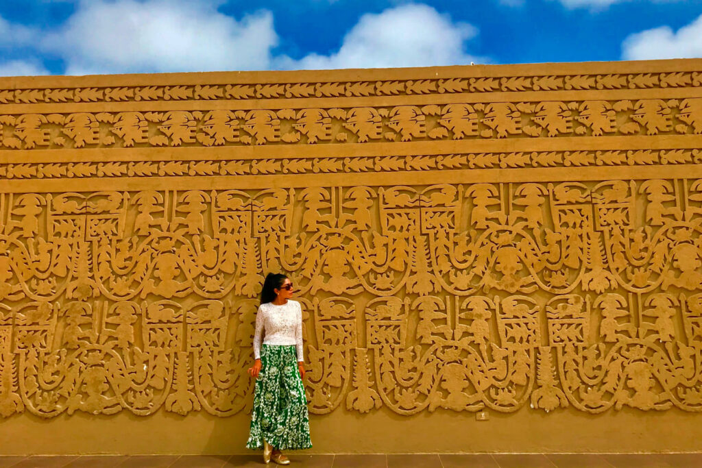 Visitante observando los relieves tallados en los muros de adobe de Chan Chan, ciudadela del reino Chimú y Patrimonio de la Humanidad en Trujillo, Perú