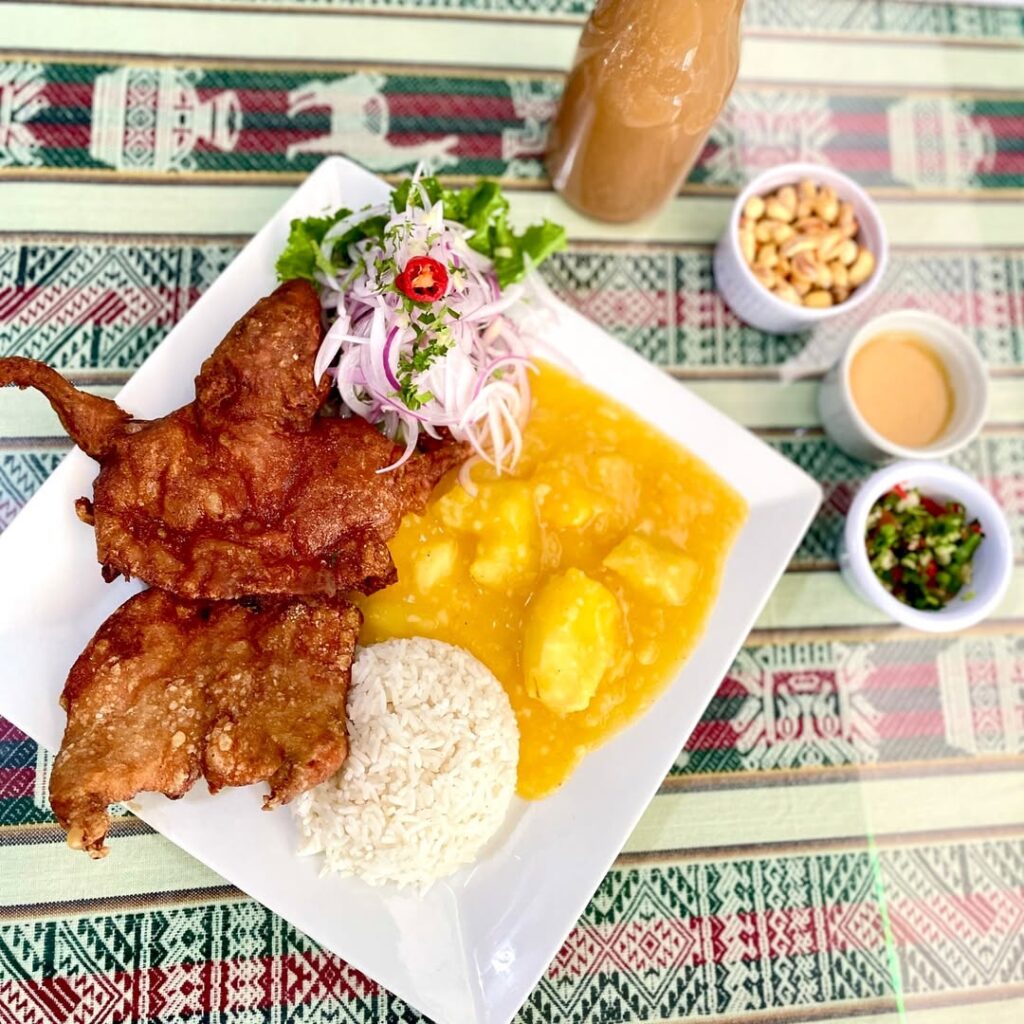 Plato típico de cuy frito con papas, arroz y ensalada servido en Udima, muestra de la gastronomía cajamarquina