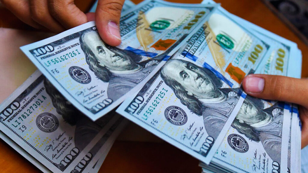 Billetes de cien dólares estadounidenses en manos de una persona