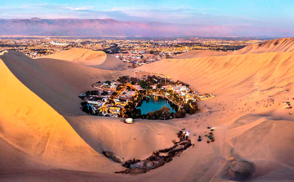 Vista panorámica del oasis de Huacachina rodeado de dunas en Ica durante temporada baja