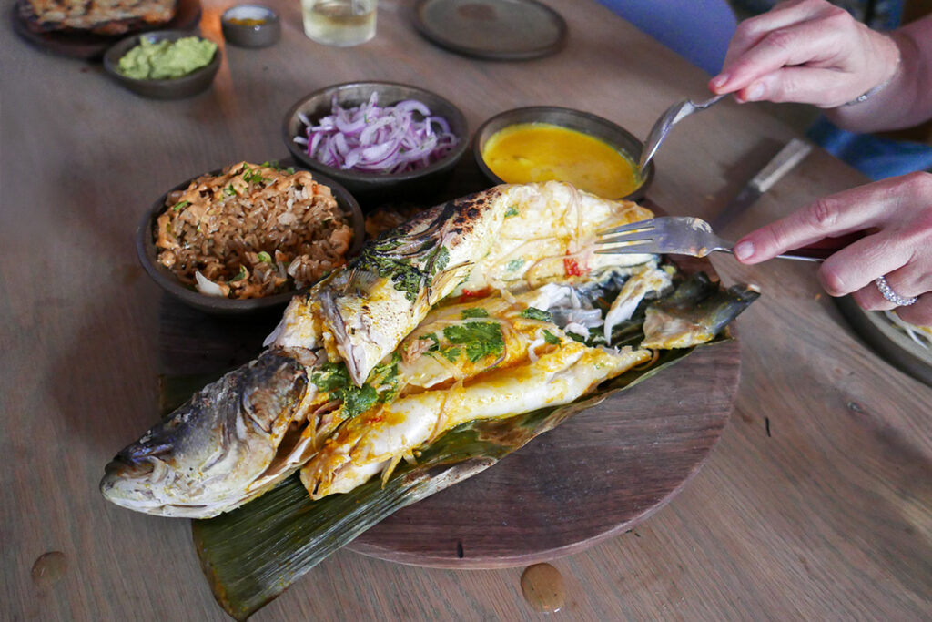 Pescado amazónico cocido y servido con guarniciones típicas, acompañado de salsa y cebolla, ejemplo de la base de pescado en la gastronomía selvática del Perú