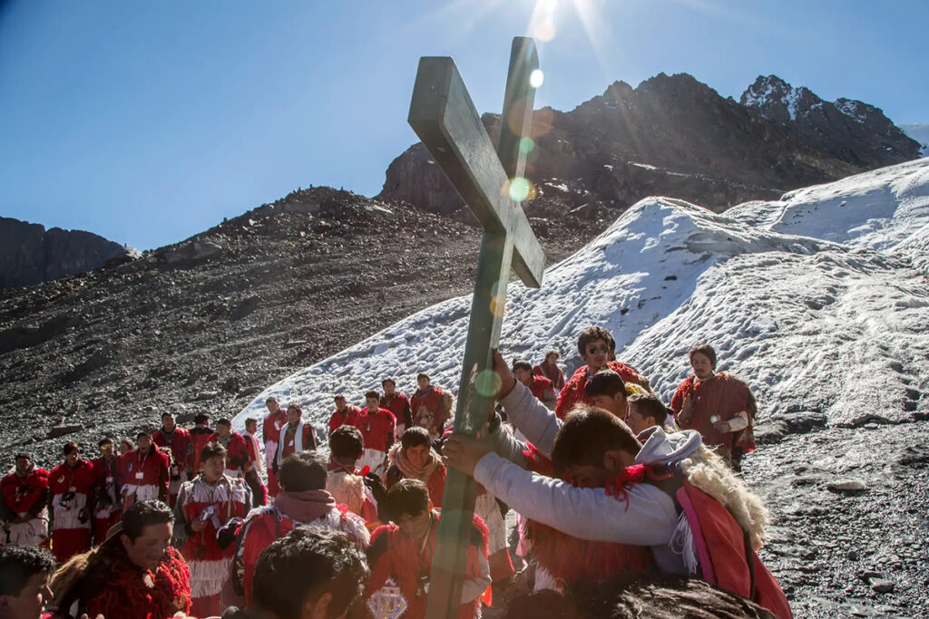 Peregrinos del Qoyllurit’i cargando una cruz durante la procesión en el valle de Sinakara, Cusco