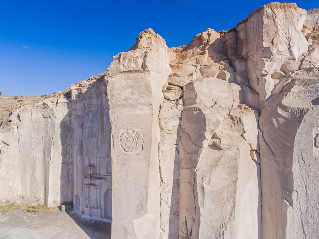Formación rocosa de sillar en la cantera de Añashuayco en Arequipa, con tallados en piedra blanca bajo un cielo despejado