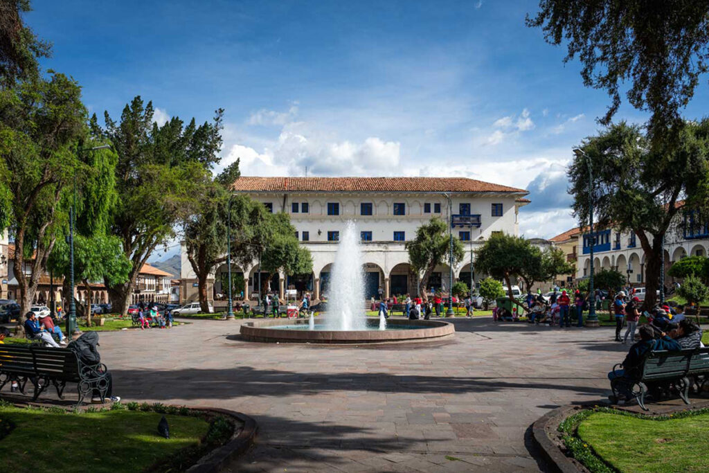 Vista de la Plazoleta Regocijo en Cusco, con fuente central, áreas verdes y casonas coloniales alrededor
