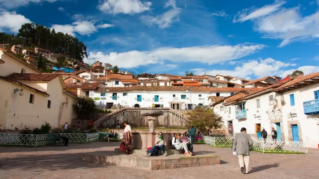 Vista de la Plazoleta San Blas en Cusco, con fuente central, casonas coloniales de balcones azules y ambiente bohemio