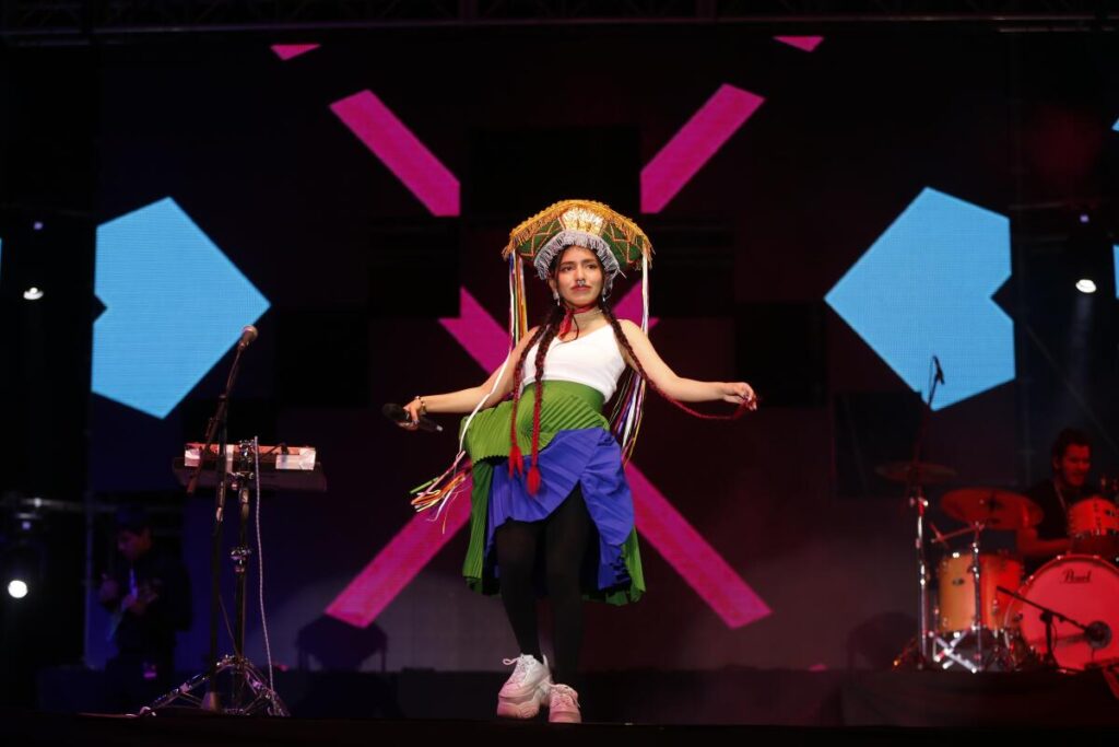 Renata Flores en un escenario internacional, interpretando música en quechua con fusión de trap y pop durante una presentación en vivo