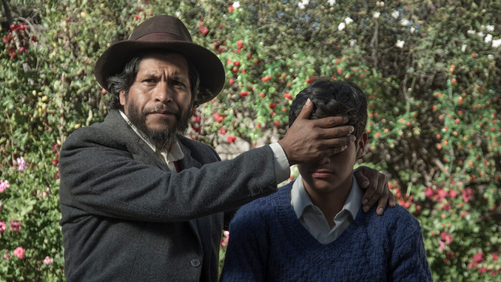 Escena de la película Retablo (2017), filmada en quechua ayacuchano, donde un hombre cubre los ojos de un adolescente en un entorno andino