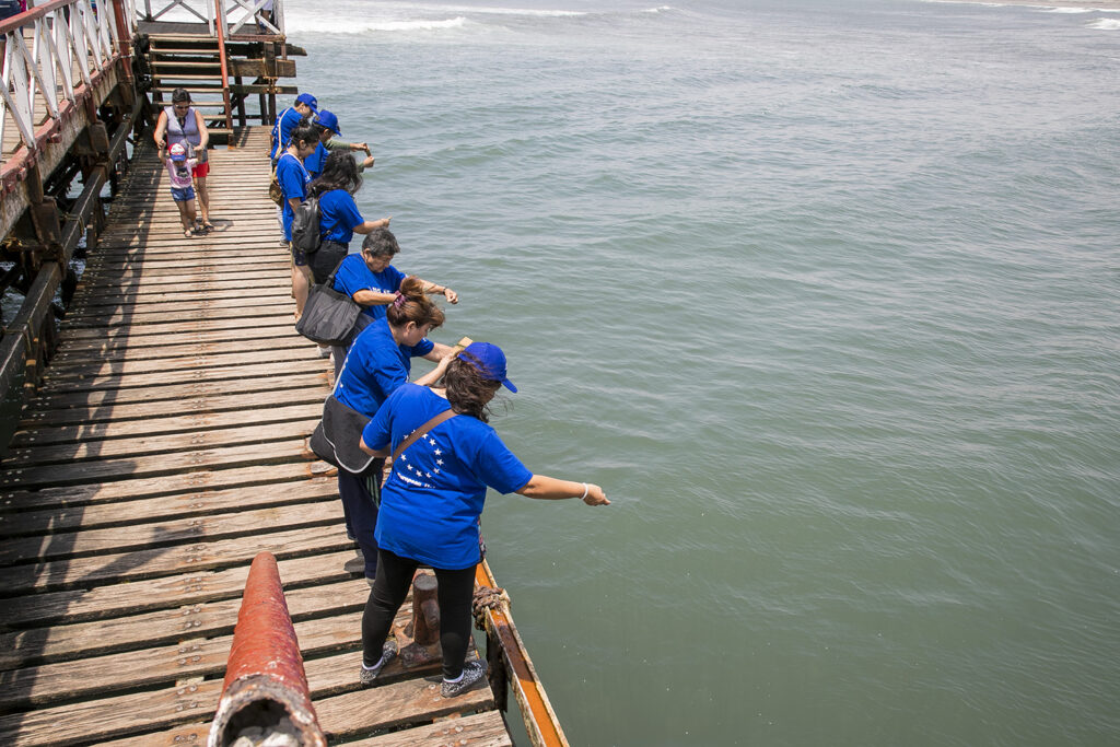Turistas participando en un taller de pesca artesanal desde el muelle de Huanchaco, costa norte del Perú