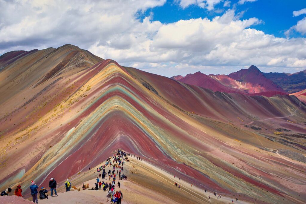 Turistas en la montaña Vinicunca, recorriendo los senderos y miradores de la famosa montaña de colores en Cusco