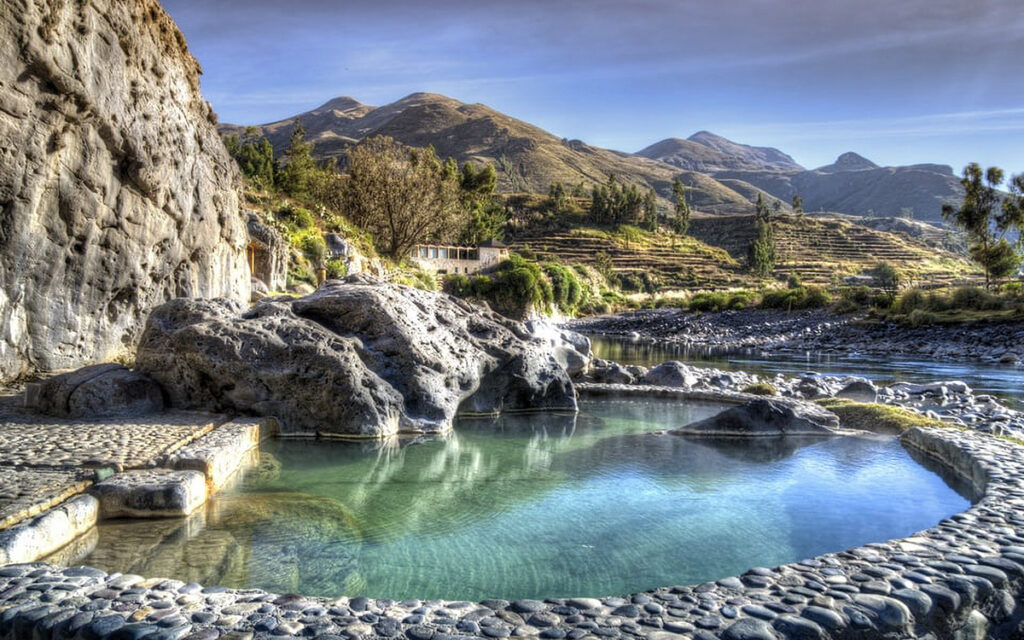 Piscinas naturales de aguas termales en Chivay con montañas del Cañón del Colca al fondo