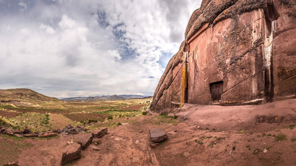 Panorámica del portal de Aramu Muru en Hayu Marca, Puno, rodeado por el paisaje del altiplano y bajo un cielo nublado sobre la pampa andina