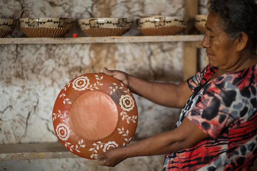Artesana kichwa de Chazuta mostrando un plato de cerámica tradicional decorado con motivos florales