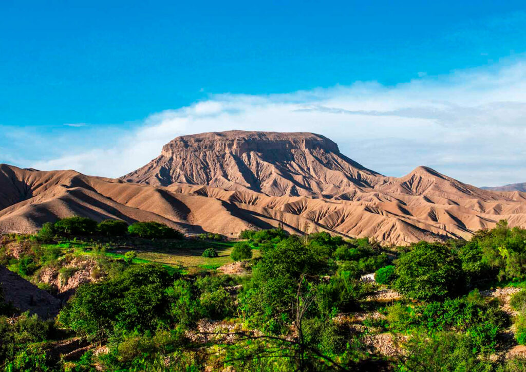Vista panorámica del Cerro Baúl en Moquegua, antiguo enclave Wari sobre el valle rodeado de vegetación y cielo despejad